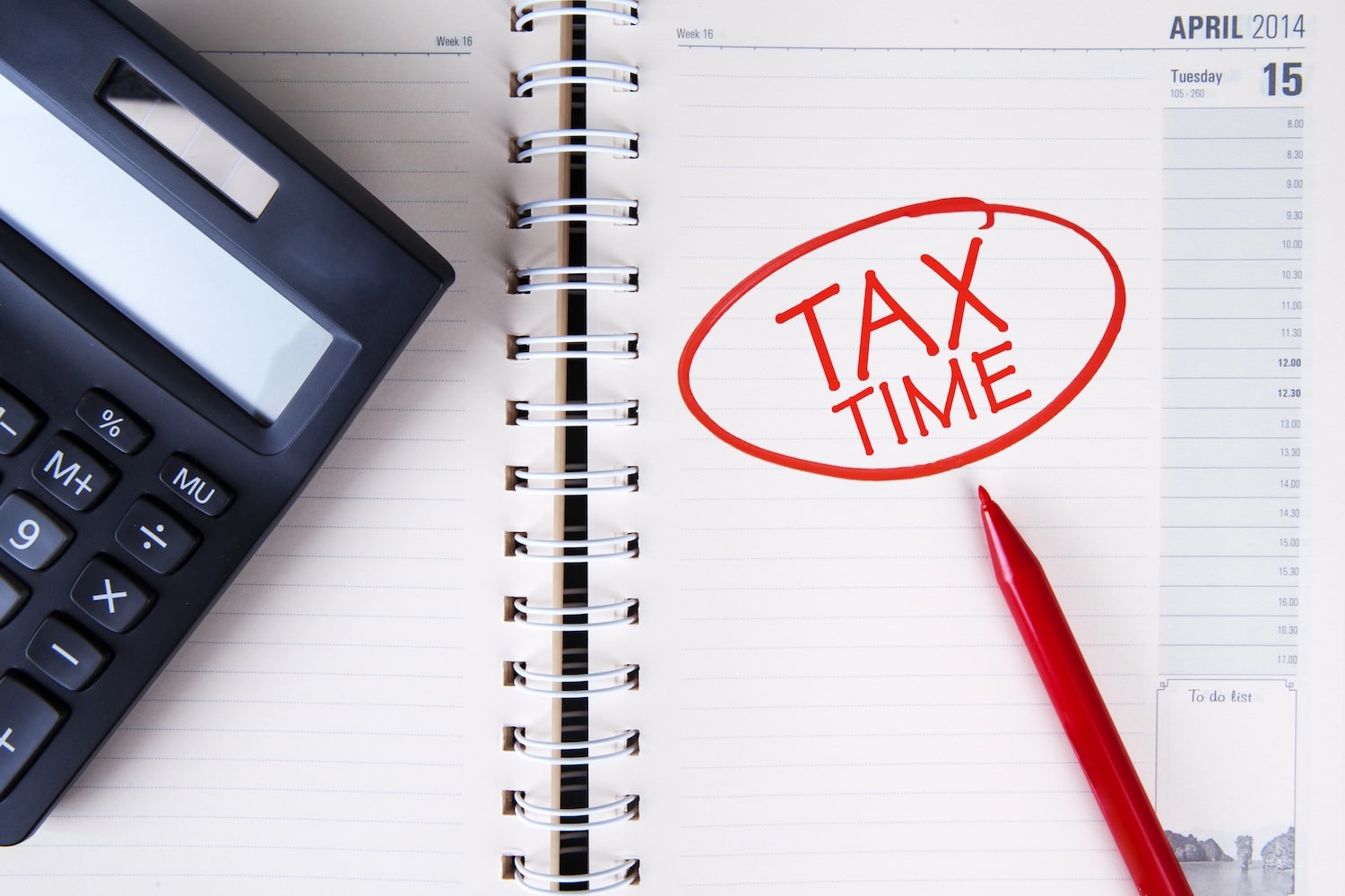 calculator, notebook and red pan with "tax time" circled