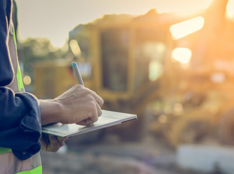 Business owner evaluating equipment on a job site before a year-end purchase decision